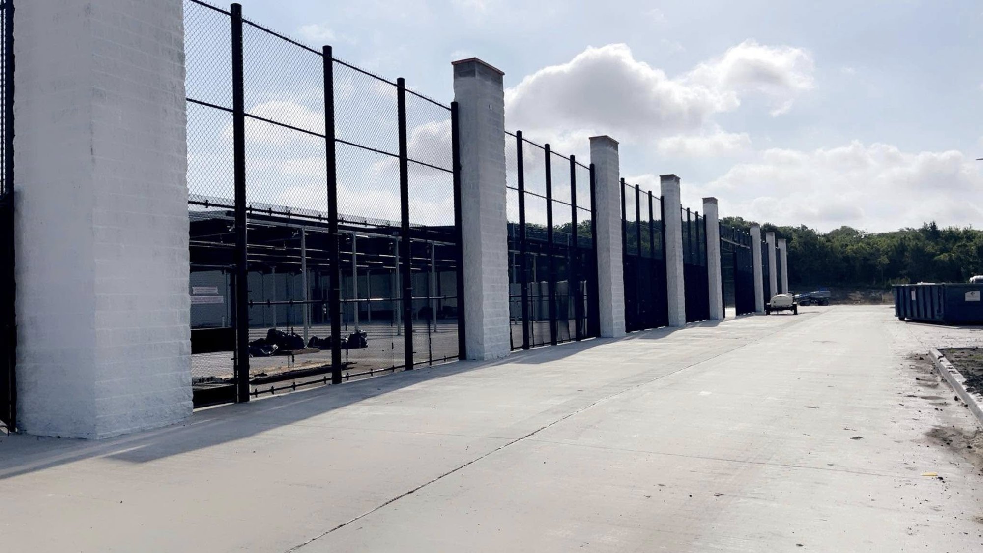 Commercial chain-link perimeter fence with brick columns installed by Gadsden Fence LLC